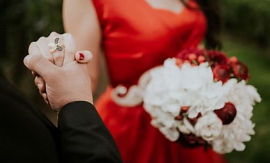 A man and woman holding hands in front of each other.